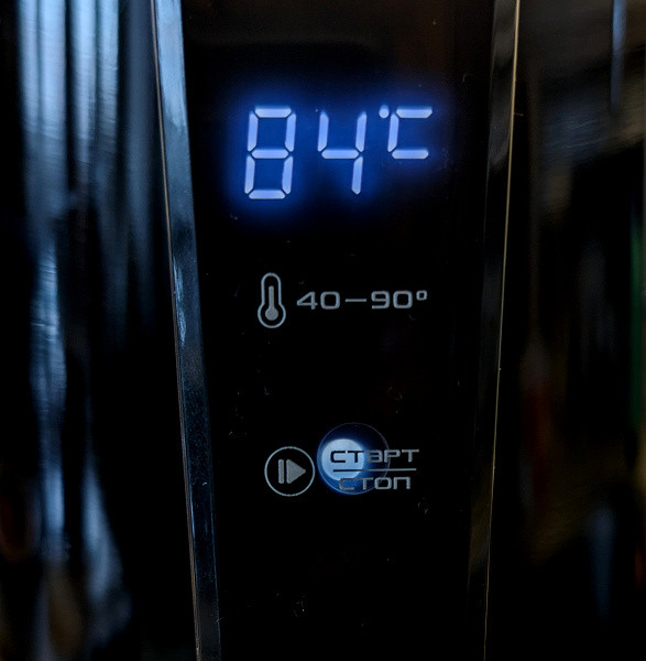 The current water temperature is displayed on a blue digital LED display located above the control buttons.