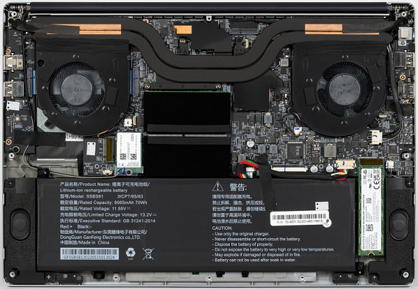 The quality of factory soldering does not raise any questions, since the process is carried out on automated lines, but the assembly requires improvements: the antenna wires of the wireless adapter and the fan power supply are not sufficiently protected, as is the battery power cable. Extensive use of adhesive tape for fixation.The interior of the case is dominated by the cooling system, battery, slots for RAM modules and speaker mounts. The printed circuit board is made in a split design and consists of two parts, the main one and an additional right satellite, which is on the left in the image.