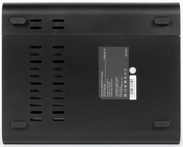 The top of the device doesn't have any special details. On the bottom, you can see the factory stickers with the model ID, MAC address, and barcode, as well as rubber supports and ventilation slots for the cooling system.