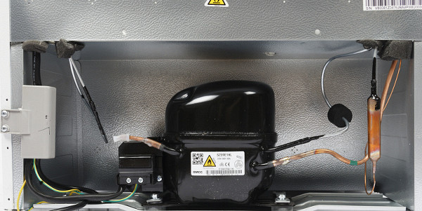 The niche for the refrigeration unit is located at the bottom of the device. The design uses a SZ59E1HL GMCC/Toshiba compressor, which is a fairly common model with a good reputation. The cooling system is filled with R600a refrigerant.