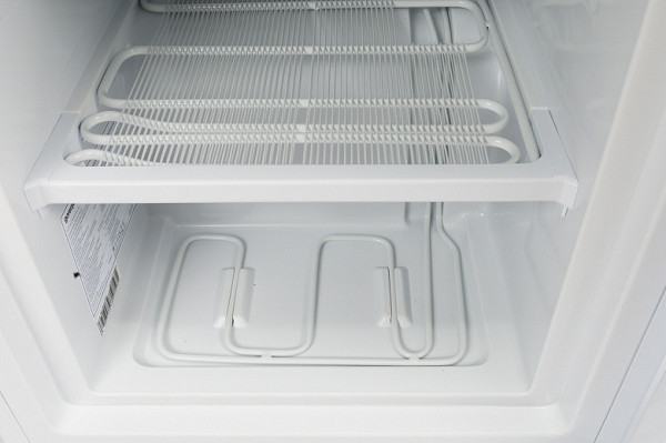 This model uses white painted steel evaporator grates as dividers. These grates are installed above each drawer, and the fourth pipe runs in the «floor» of the freezer.