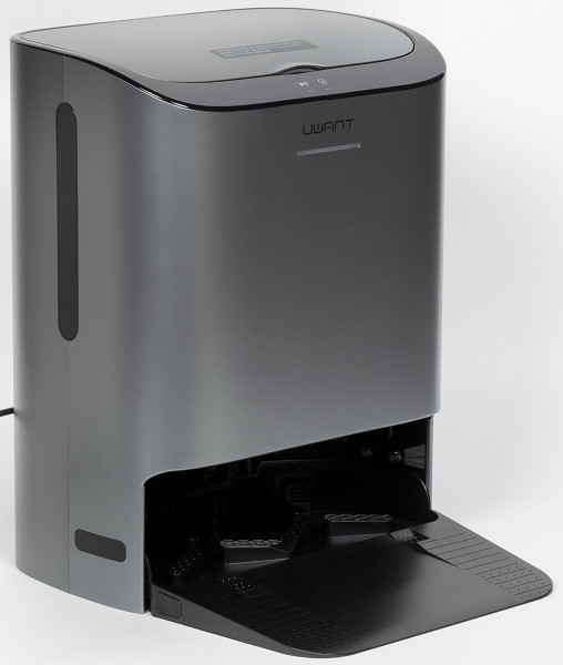 The base is made of dark silver plastic and has the shape of a parallelepiped with beveled corners. At the bottom of the front panel there is a niche into which the vacuum cleaner moves to empty the dustbin, wash napkins and charge the battery.